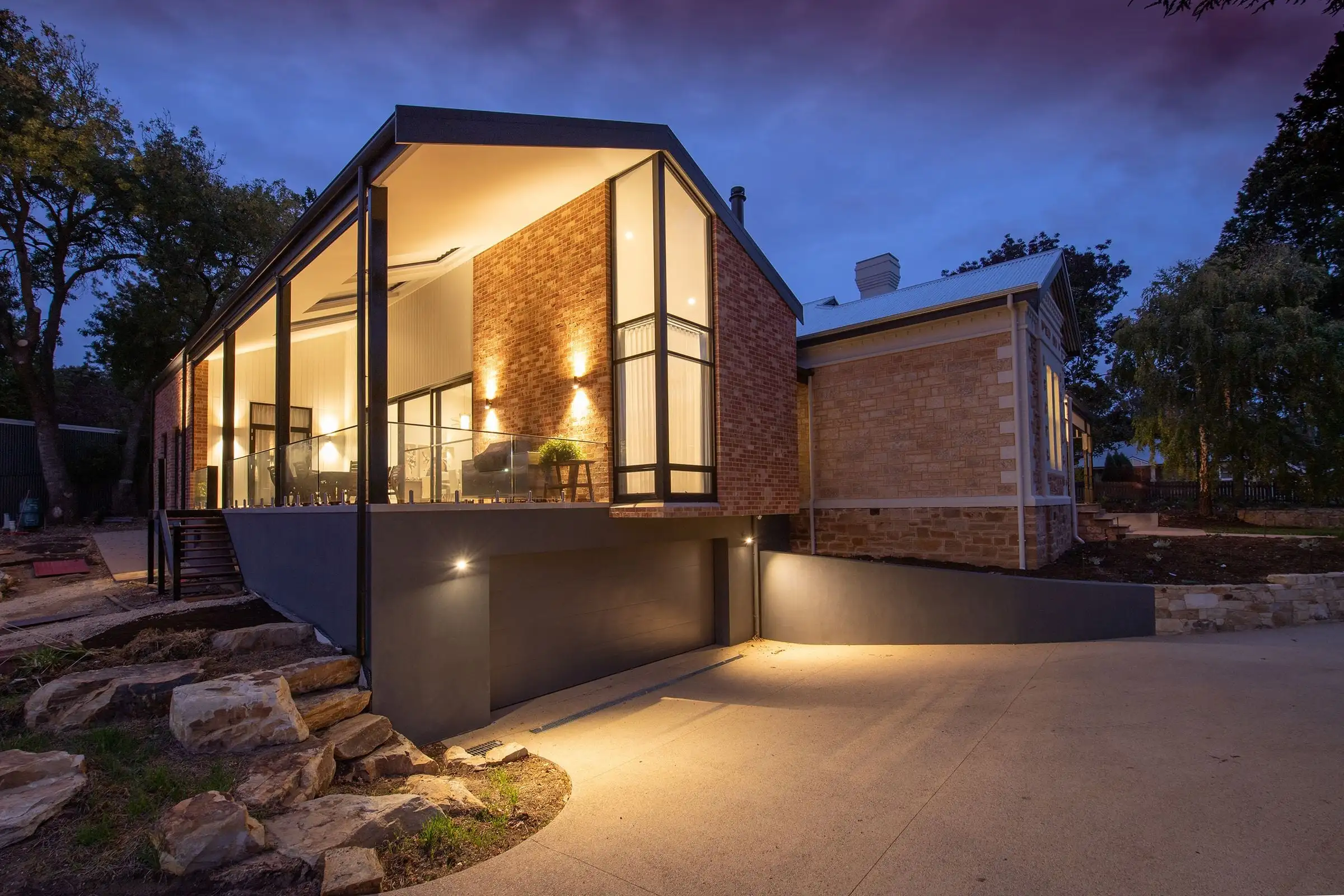Independent home at dusk with warm interior light, representational image